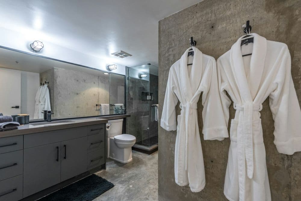 Batas blancas colgadas en un baño de hotel