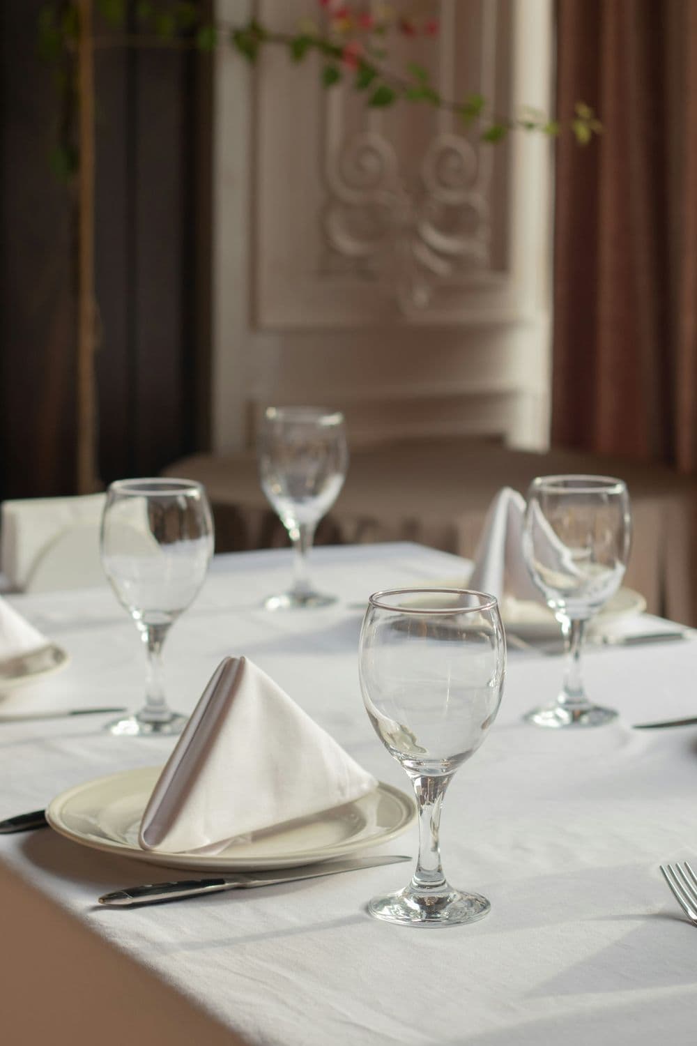 Mesa de restaurante con mantel blanco y servilletas
